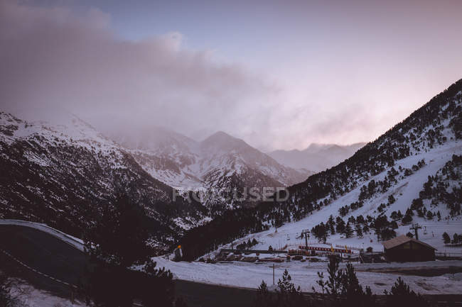 Vista pitoresca para belas montanhas nevadas e pequena casa no dia de inverno . — Fotografia de Stock