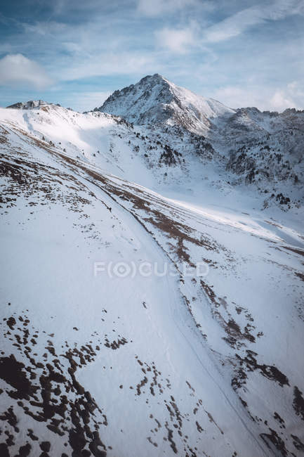 Luftaufnahme von verschneiten Bergen vor dem Hintergrund einer idyllischen Wolkenlandschaft — Stockfoto