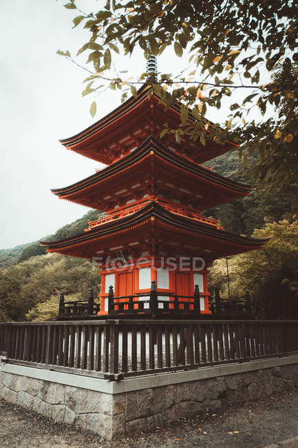 Traditional Asian red pagoda tower in green forest. — Stock Photo