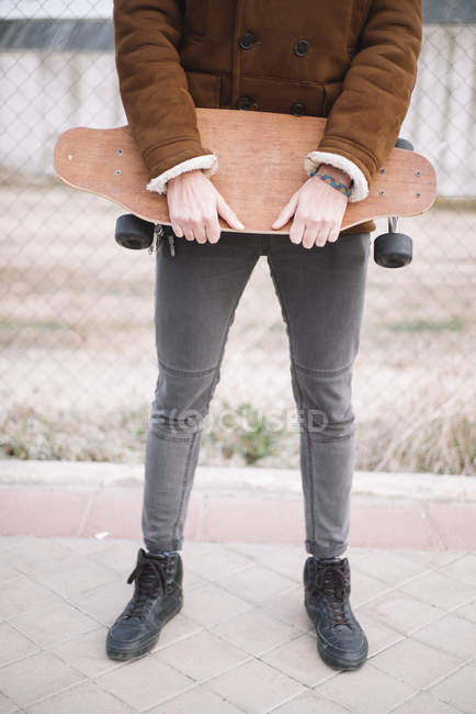 Low section of man holding skateboard — Stock Photo