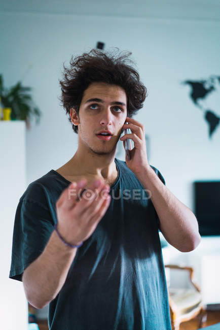 Портрет людини, що розмовляє по телефону вдома — стокове фото