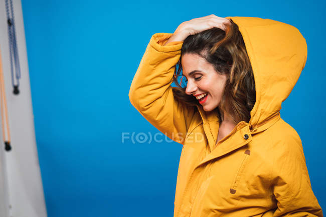 Вид сбоку веселой женщины в желтой куртке — стоковое фото