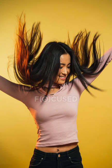 Portrait of cheerful young woman jumping on yellow background — Stock Photo