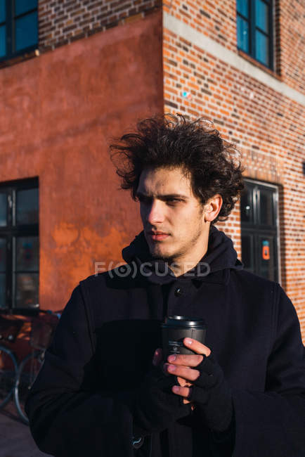 Jovem com café olhando para longe na rua — Fotografia de Stock