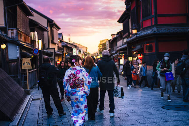 Back view of woman in Asian traditional clothes walking in town. — Stock Photo