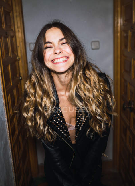 Young expressive woman in jacket and bra smiling with eyes closed. — Stock Photo