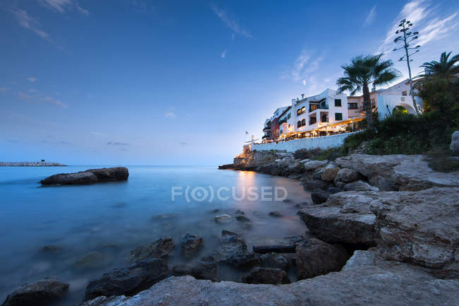 Low angle view of tranquil bay and white villa on shore — Stock Photo
