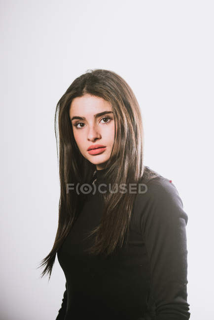 Portrait brunette girl posing in studio and looking at camera — Stock Photo