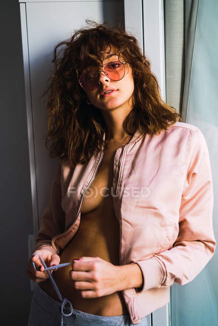 Портрет жінки в рожевій куртці і жовтих сонцезахисних окулярах — стокове фото