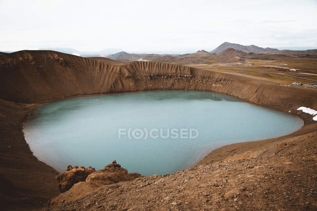 Pequeno lago com água azul em terreno de montanha — Fotografia de Stock