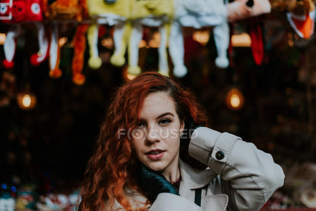 Junge rothaarige Frau blickt in die Kamera und posiert vor dem Hintergrund des Marktes — Stockfoto