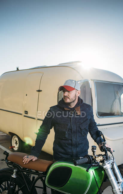 Портрет мужчины, позирующего с мотоциклом возле фургона — стоковое фото