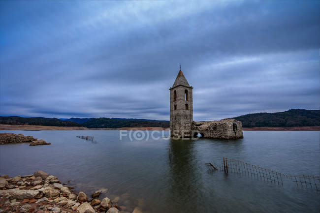 Bell tower submerged in calm lake at dusk — Stock Photo