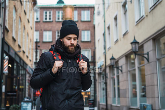 Ritratto di zaino in spalla barbuto passeggiando in città — Foto stock