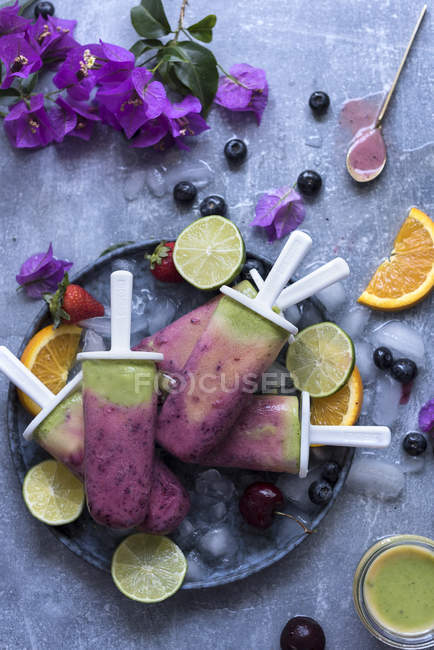Composição de picolés de smoothie de frutas e fatias de frutas — Fotografia de Stock