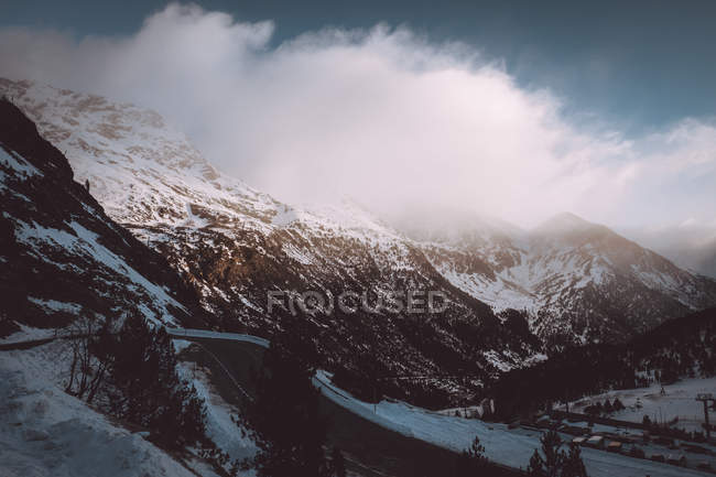 Malerische Berglandschaft mit sonnenbeschienenen, üppigen Wolken, die im blauen Himmel schweben — Stockfoto
