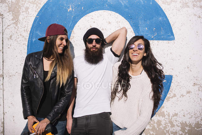Group of smiling friends posing at street scene — Stock Photo