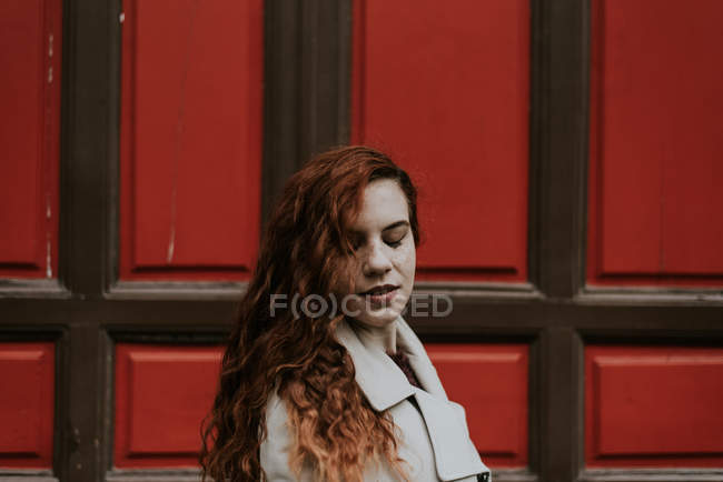 Redhead woman posing with closed eyes on street — Stock Photo