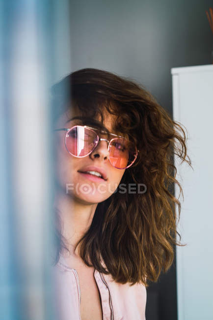 Портрет жінки в сонцезахисних окулярах дивиться на камеру — стокове фото