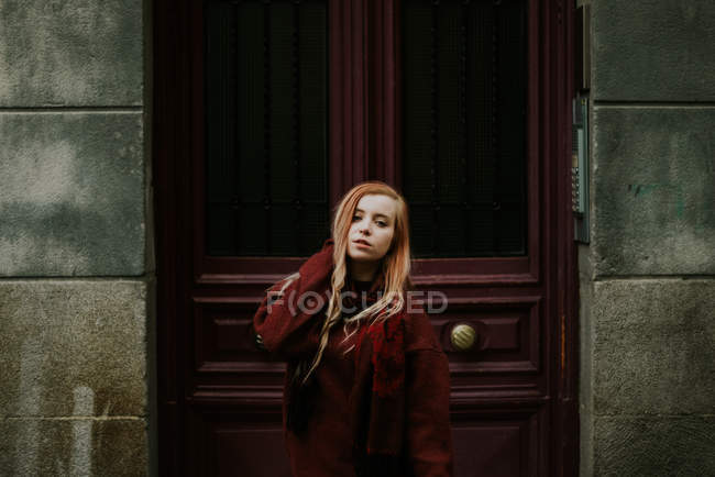 Blonde woman in sweater posing at door — Stock Photo