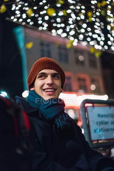 Portrait d'homme joyeux en vêtements chauds la nuit scène de rue — Photo de stock