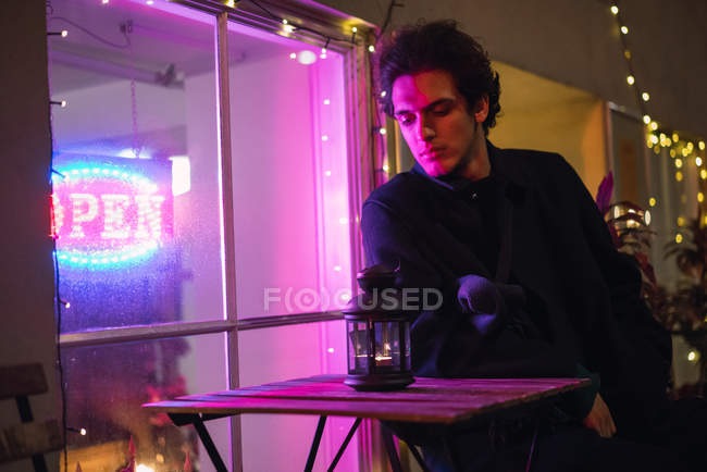 Porträt eines Mannes, der am Tisch am beleuchteten Fenster sitzt — Stockfoto