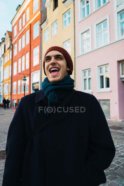 Laughing man walking on street and looking up — Stock Photo