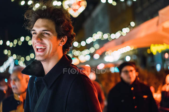 Cheerful man smiling on city street in evening. — Stock Photo