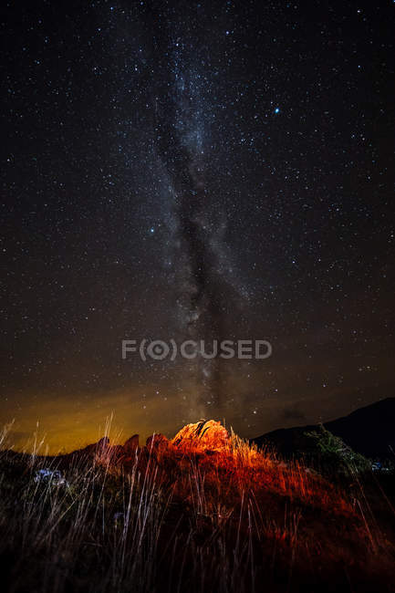 Lit barraca turística na colina sobre a forma leitosa no céu noturno — Fotografia de Stock