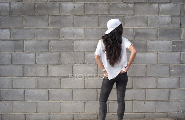 Vue arrière de la fille brune posant sur la scène de rue — Photo de stock