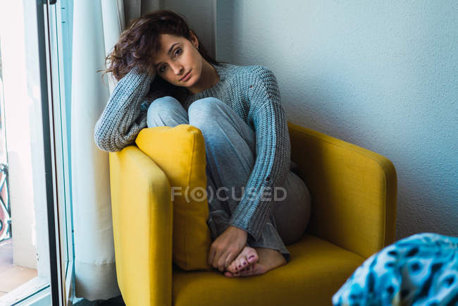 Ritratto di giovane donna seduta e rilassante in poltrona a casa . — Foto stock