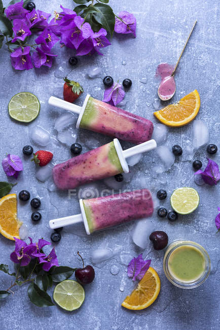 Still life of fruit smoothie popsicles and fruit slices — Stock Photo