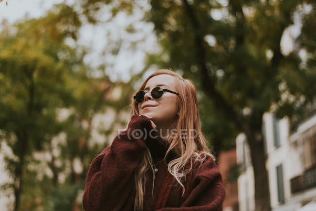 Красива молода жінка в сонцезахисних окулярах позує на міській вулиці . — стокове фото