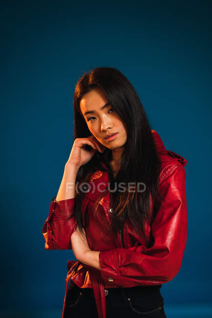 Portrait of young woman touching chin and looking at camera — Stock Photo