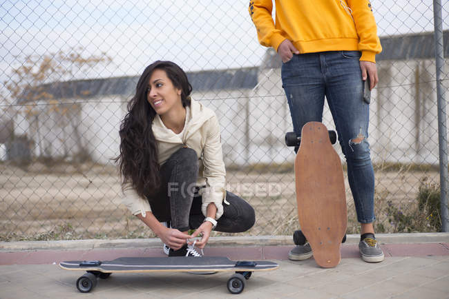 Two girls with longboards posing at street scene — Stock Photo
