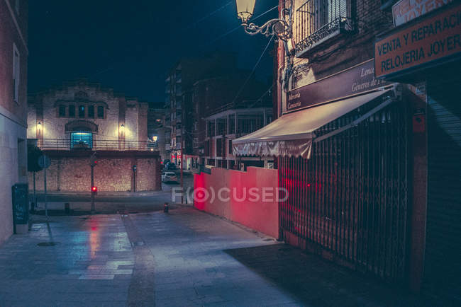 Szene einer leeren Straße mit beleuchteten Geschäften in der Nacht. — Stockfoto