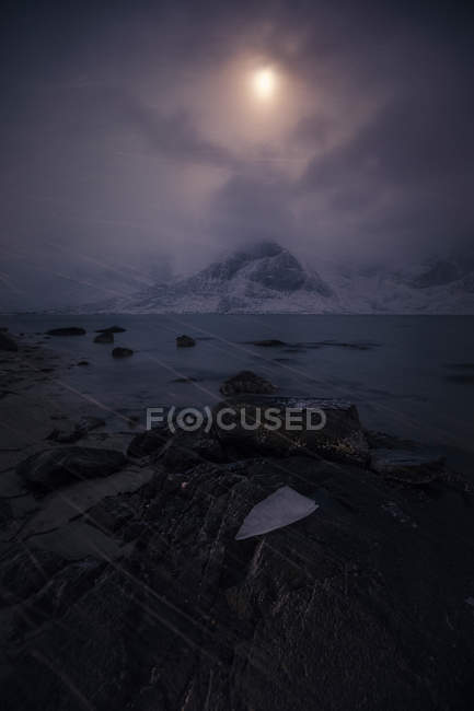 View to mountains lake covered with snow in evening dusk — Stock Photo