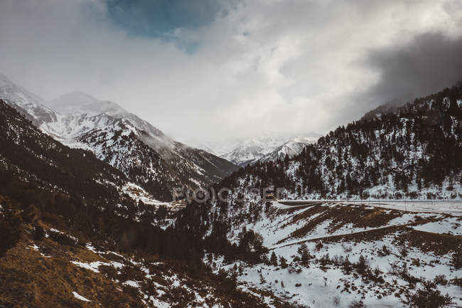 Malerische Landschaft des schneebedeckten Gebirgstals vor idyllischer Wolkenlandschaft — Stockfoto