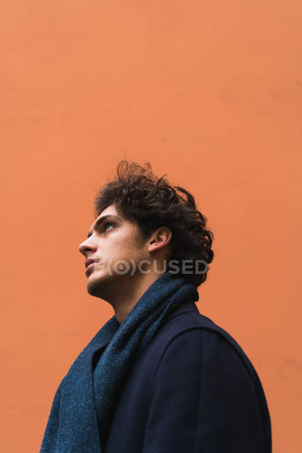 Seitenansicht von Mann posiert auf orangefarbener Wand — Stockfoto