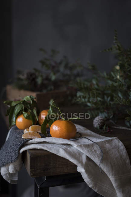 Still life of ripe Mandarin oranges with branches on table. — Stock Photo