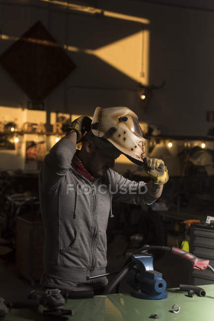 Side view of professional welder setting welder mask — Stock Photo