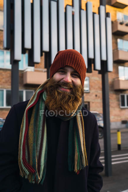 Homme barbu souriant regardant la caméra sur la rue  . — Photo de stock