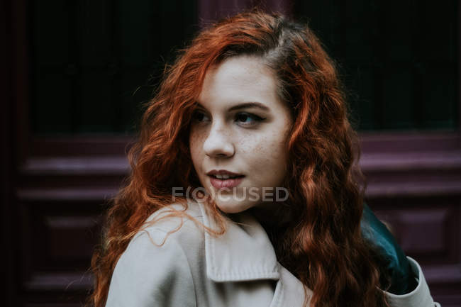 Jovem ruiva posando na rua e olhando para longe . — Fotografia de Stock