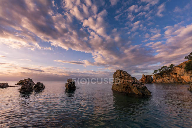 Panorama de costa rochosa sob paisagem nebulosa cênica — Fotografia de Stock
