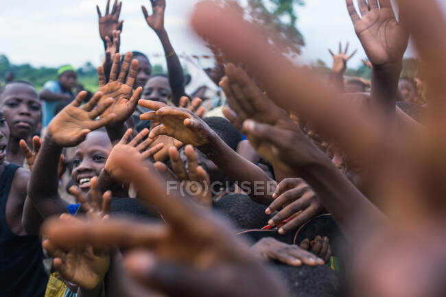 BENIN, ÁFRICA - 31 DE AGOSTO DE 2017: Crianças africanas alegres com as mãos no ar — Fotografia de Stock