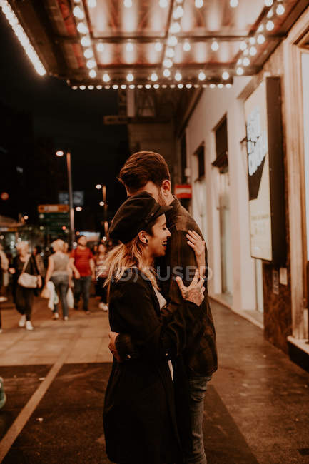 Side view of couple embracing on evening street — Stock Photo