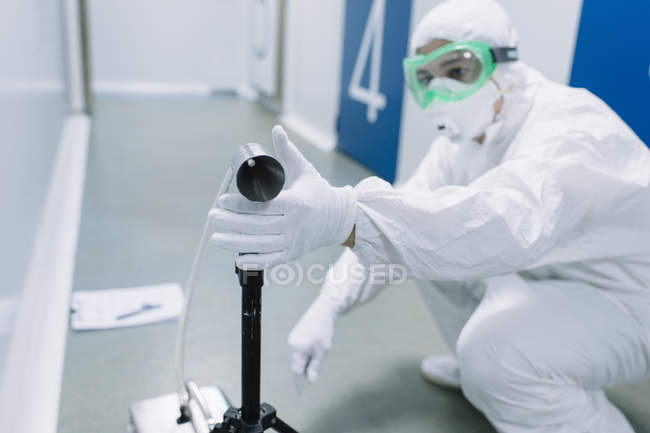 Scientifique organisant le dispositif sur le sol dans le laboratoire
. — Photo de stock