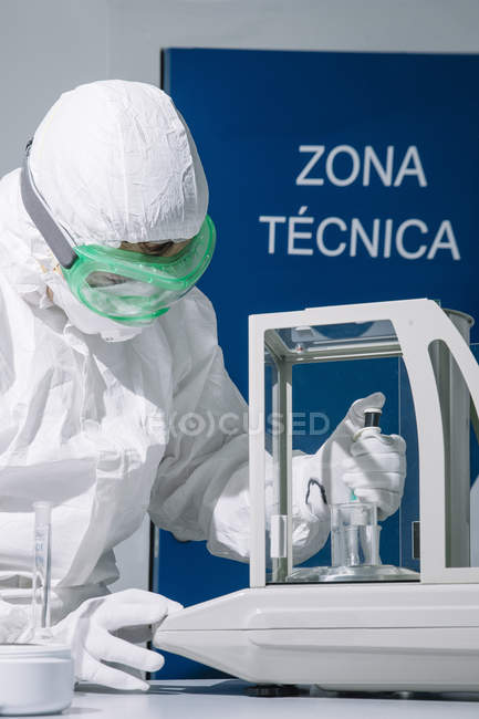 Scientist using pipette and scales at laboratory — Stock Photo