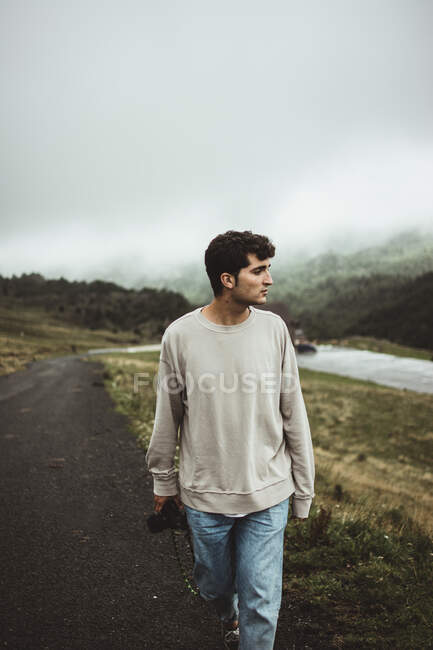 Man with camera walking in countryside — Stock Photo