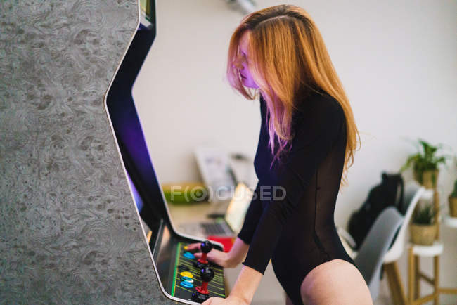 Vista laterale della donna rossa che gioca al videogioco — Foto stock